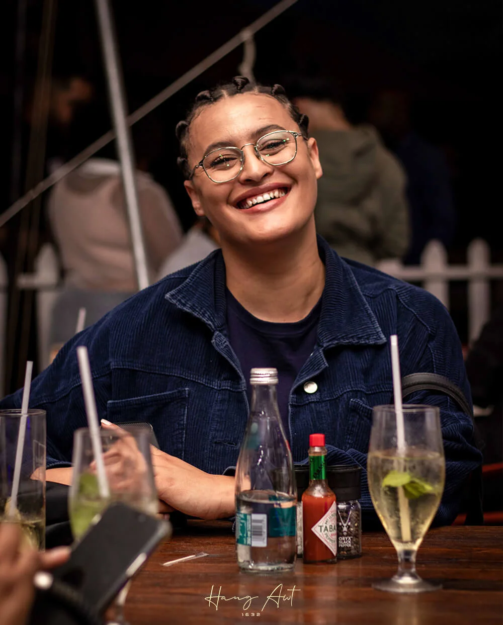 Guest laughing over drinks at Hang Awt